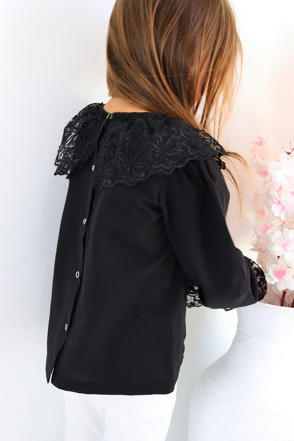 Schwarzes Langarmshirt mit Spitzendetails am Kragen und an den Ärmelenden