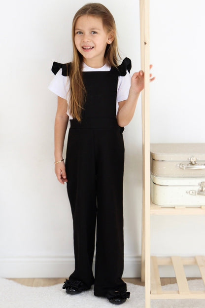 Schwarze Salopette Berlin - Jumpsuit in Schwarz mit Volantschultern und Haarspange