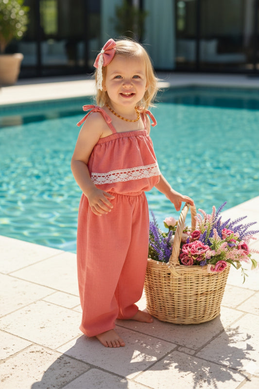 Jumpsuit Pera - Lachsfarbener Jumpsuit mit Spitzendetails, schmalen Trägern und Haarspange