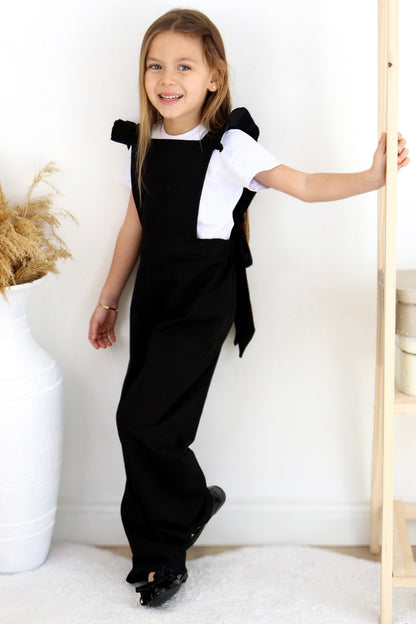 Schwarze Salopette Berlin - Jumpsuit in Schwarz mit Volantschultern und Haarspange