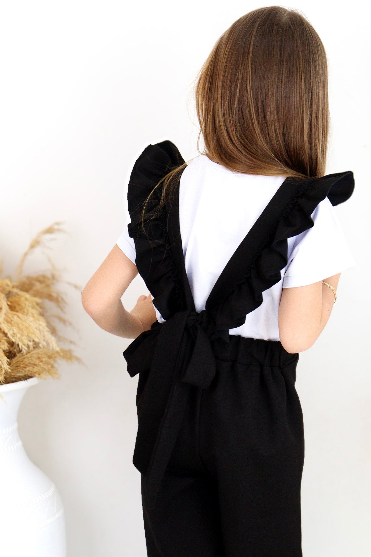 Schwarze Salopette Berlin - Jumpsuit in Schwarz mit Volantschultern und Haarspange